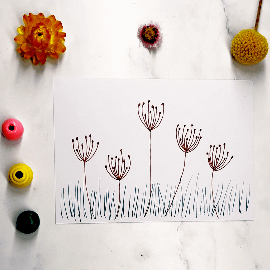 Step 4: draw simple blades of grass at the base of your flowers