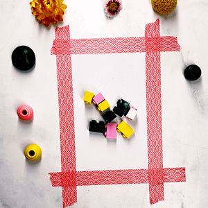 Step 1: Start by placing small objects like Lego blocks or beads in the center of your paper.