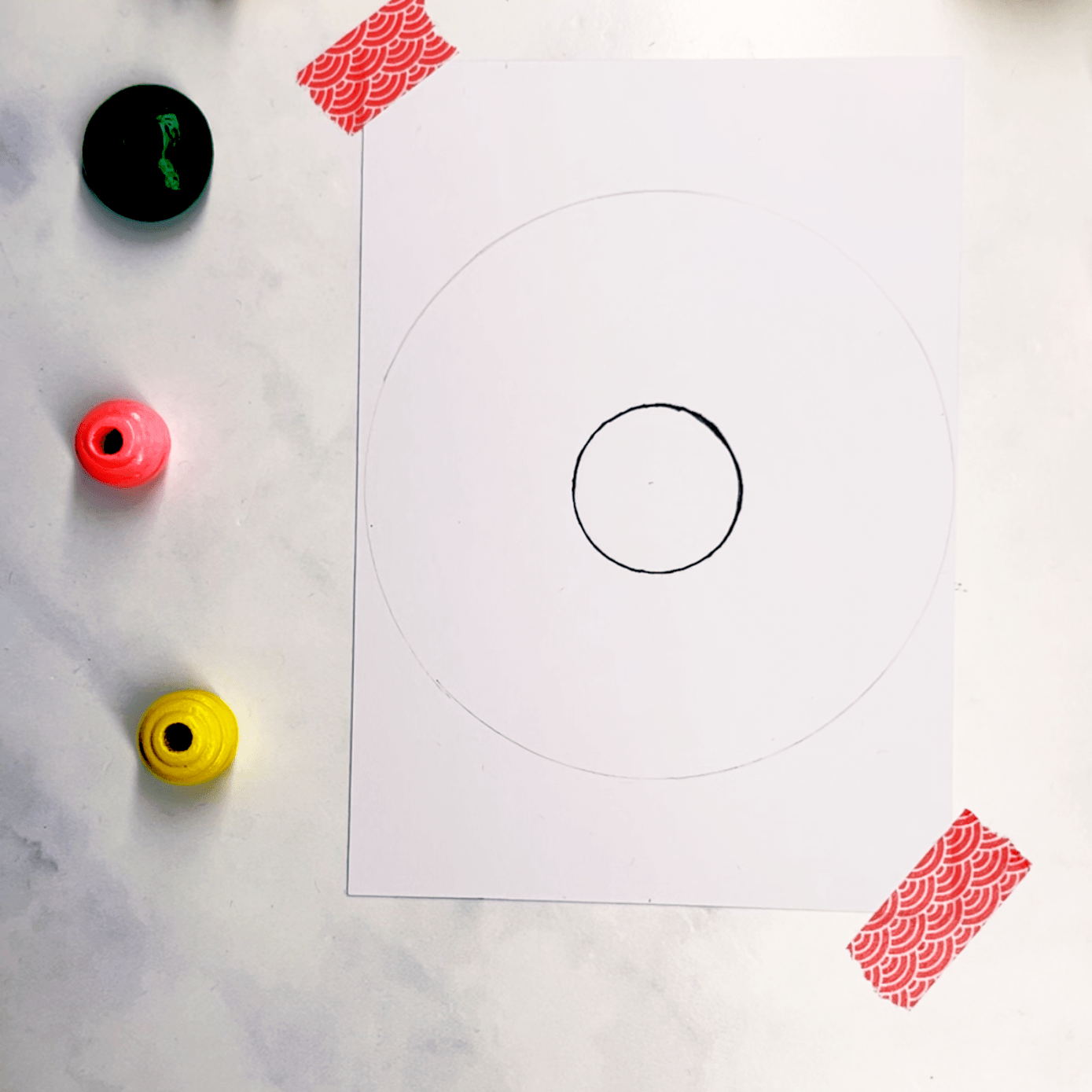Step 1: draw a small circle and a large circle on your page. Use circular objects to create these.